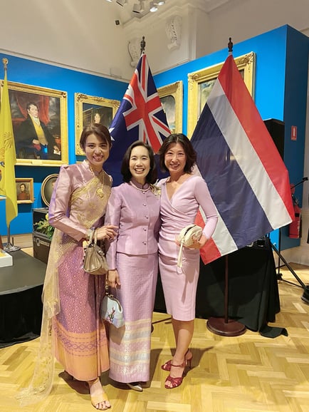 Charter Australia CEO, Ming Chen smiles for a photo with the Thai Consulate General in front of the Australian and Thai flags in the NSW Museum