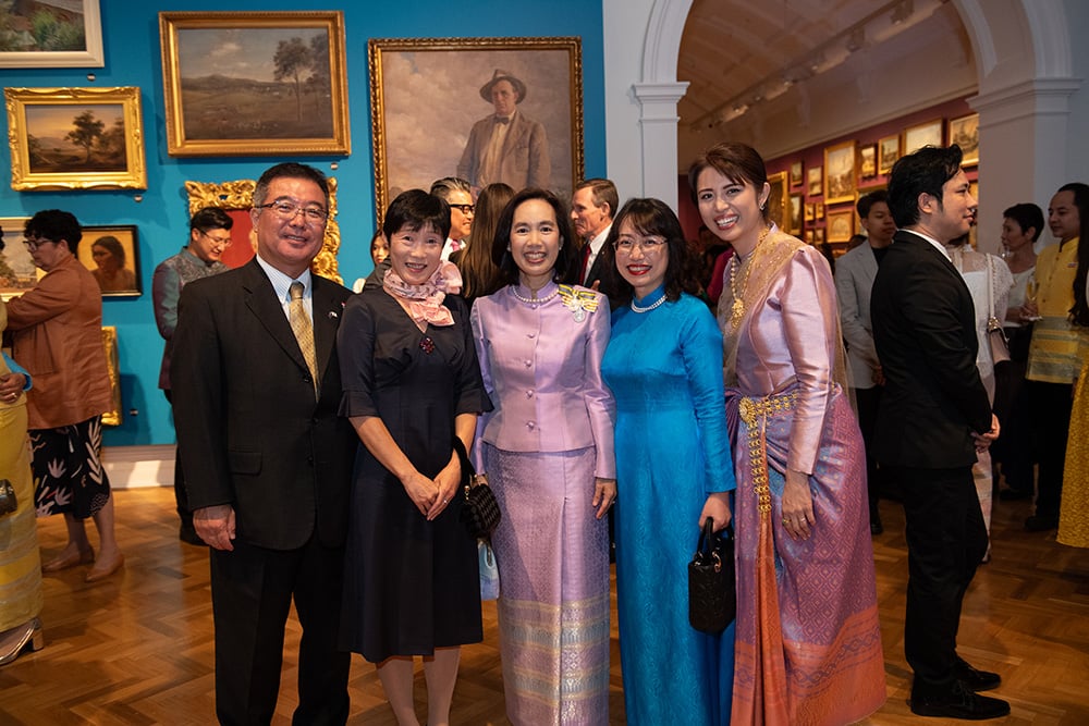 Smiling business representative and the members of the Thai General Consulate stand in the NSW Gallery for the National Thai Day event in 2023.