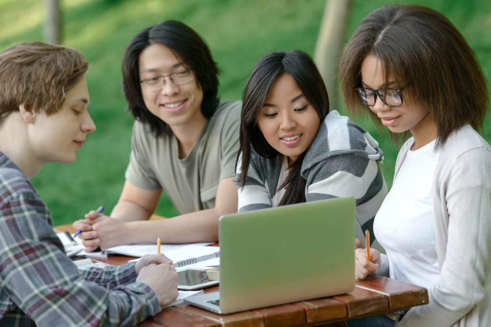 cheerful-group-young-students-sitting-studying-SMALL