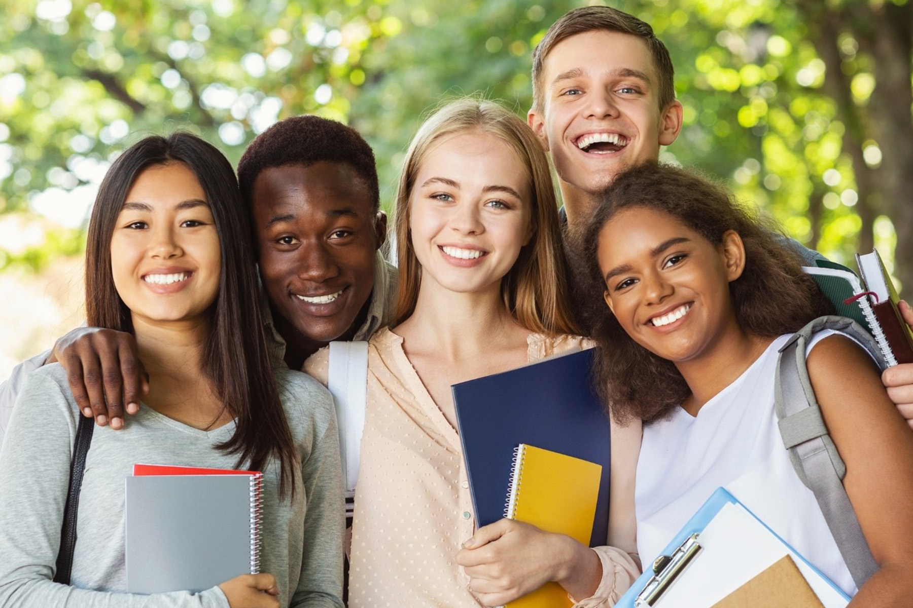 a group of international students stand outdoors smiling on campus in Sydney, NSW, Australia.